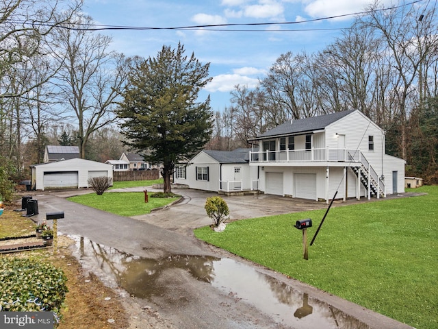 view of front of house featuring a garage, a front yard, and covered porch