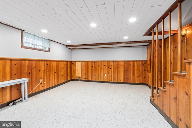 basement featuring wooden walls