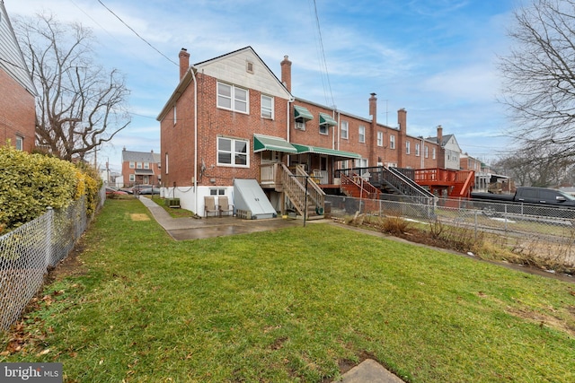 back of house with a yard and a patio