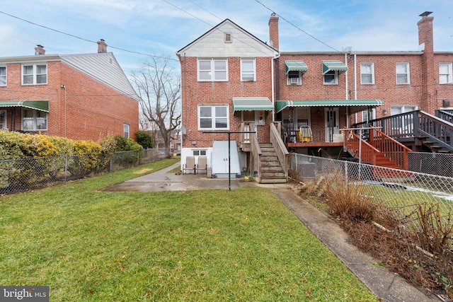 rear view of house with a patio and a lawn