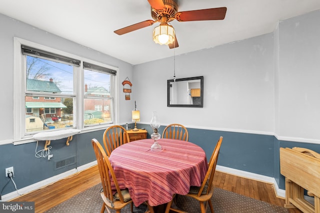 dining space with hardwood / wood-style flooring and ceiling fan