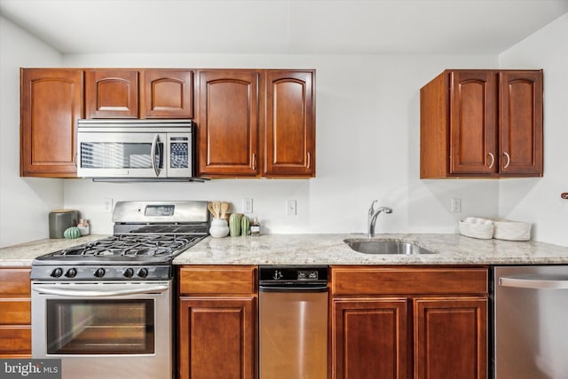 kitchen featuring light stone counters, sink, and stainless steel appliances