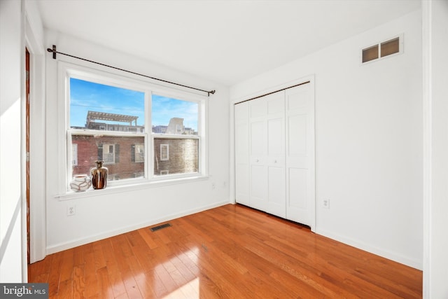 unfurnished bedroom with a closet and light hardwood / wood-style flooring