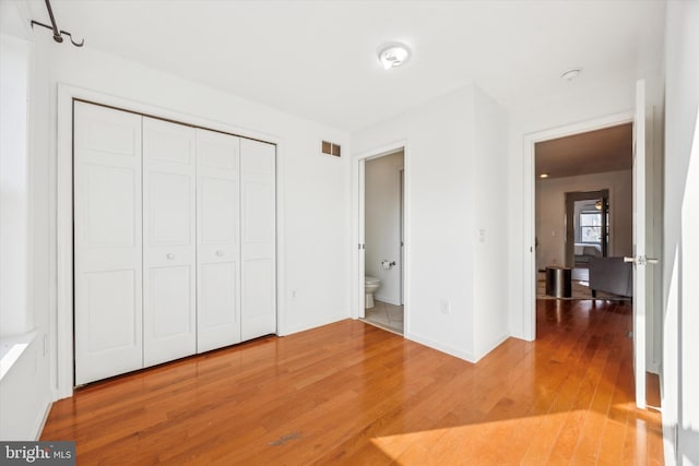 unfurnished bedroom featuring wood-type flooring and a closet