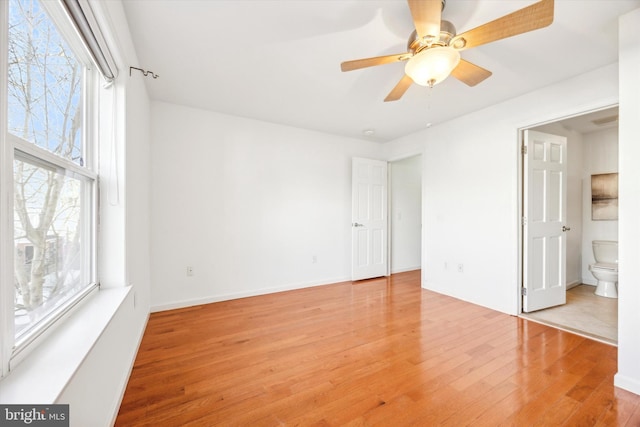 unfurnished bedroom with ensuite bathroom and light hardwood / wood-style flooring