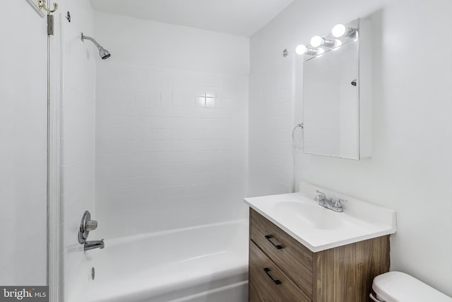 full bathroom with vanity, tiled shower / bath combo, and toilet