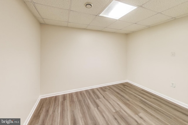 spare room with hardwood / wood-style flooring and a paneled ceiling