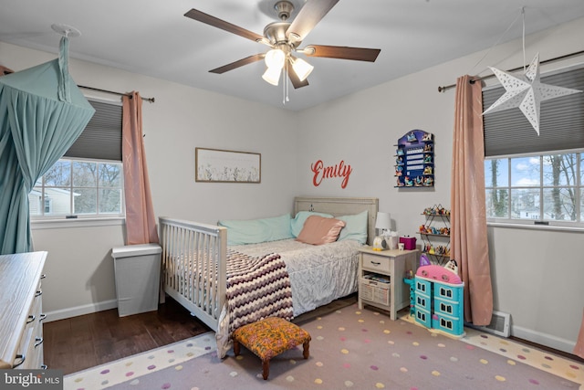 bedroom with multiple windows, ceiling fan, and dark hardwood / wood-style flooring