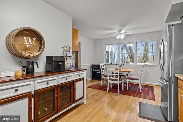 kitchen with ceiling fan, stainless steel fridge, and light wood-type flooring