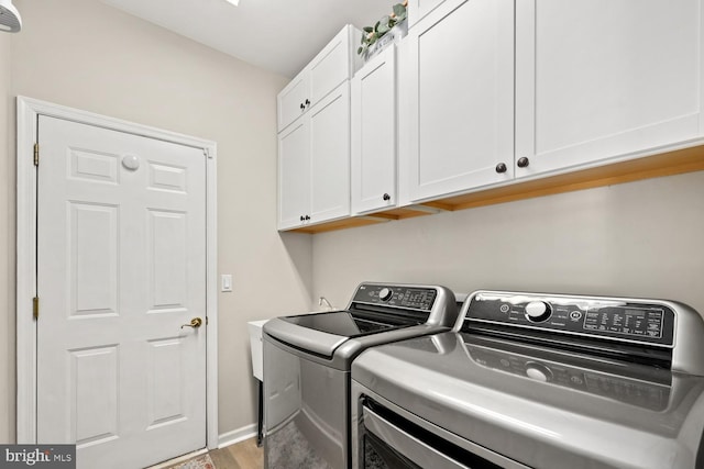 laundry room featuring independent washer and dryer and cabinets