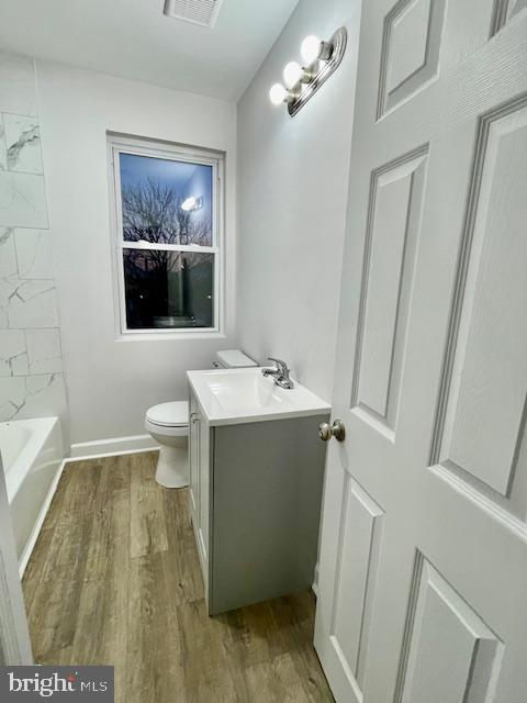 bathroom with vanity, hardwood / wood-style floors, and toilet