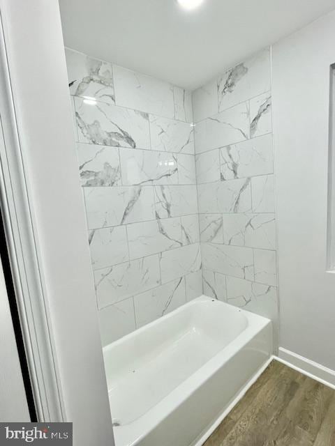 bathroom featuring hardwood / wood-style flooring and tiled shower / bath