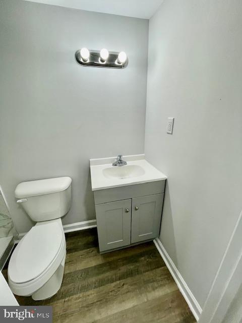 bathroom featuring vanity, hardwood / wood-style floors, and toilet