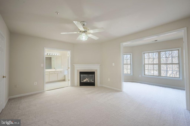 unfurnished living room featuring light colored carpet and ceiling fan