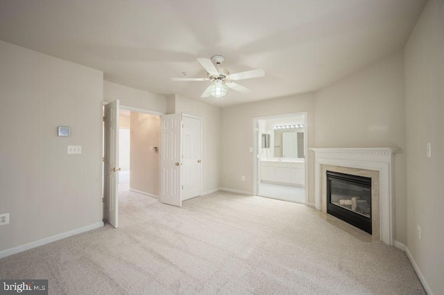 unfurnished living room featuring ceiling fan, light carpet, and a fireplace