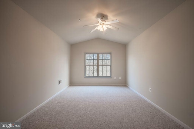 spare room with lofted ceiling, light carpet, and ceiling fan