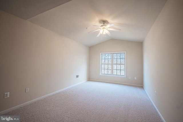 empty room with vaulted ceiling, light colored carpet, and ceiling fan