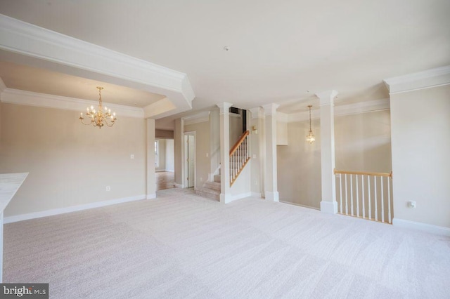 carpeted spare room with ornamental molding, decorative columns, a raised ceiling, and a chandelier