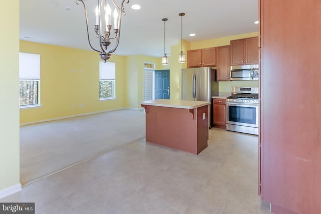 kitchen featuring a breakfast bar area, an inviting chandelier, decorative light fixtures, a center island, and appliances with stainless steel finishes