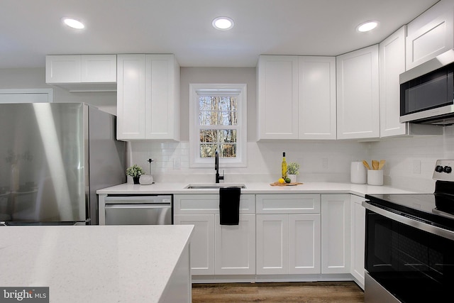 kitchen featuring white cabinetry, sink, backsplash, and stainless steel appliances