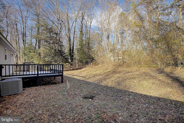 view of yard with central AC unit and a wooden deck