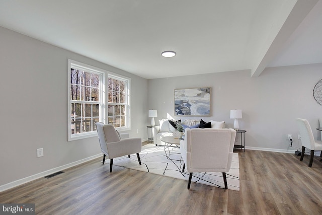 living room featuring wood-type flooring and beamed ceiling