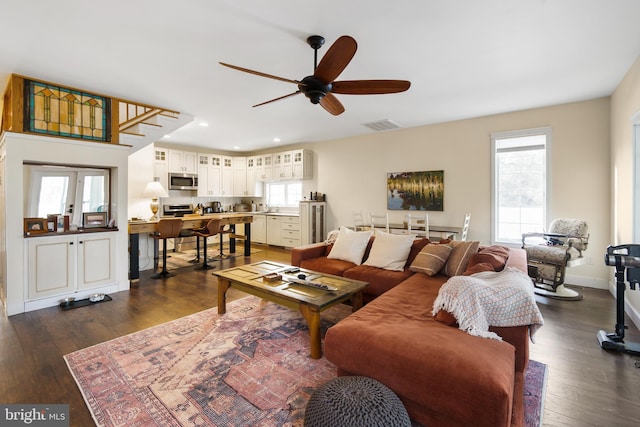 living room with dark hardwood / wood-style floors and ceiling fan