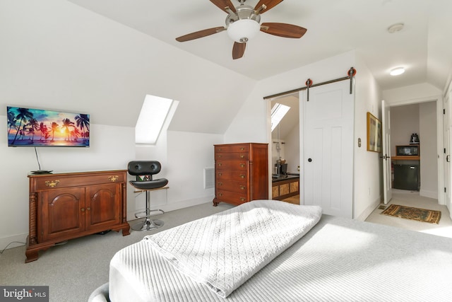 bedroom with vaulted ceiling, a barn door, light colored carpet, and ceiling fan