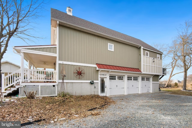 view of side of home with a garage and covered porch