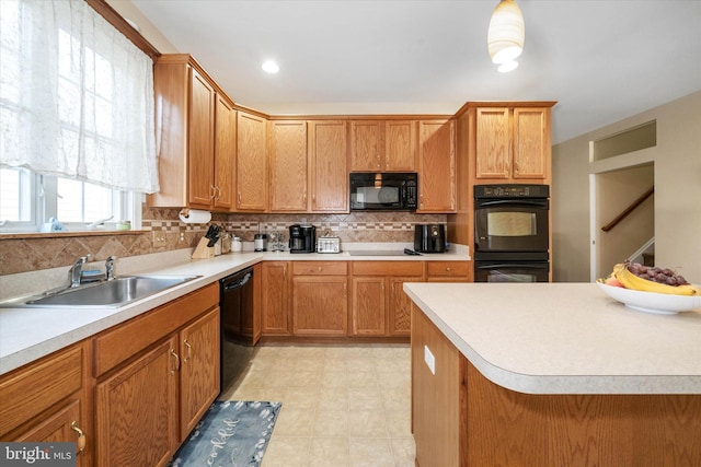 kitchen featuring sink, pendant lighting, backsplash, and black appliances