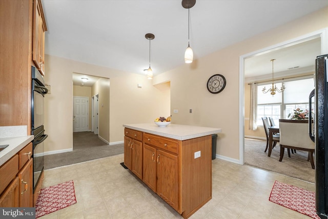 kitchen with hanging light fixtures, a center island, a notable chandelier, black fridge, and light carpet