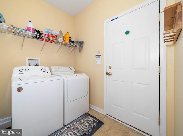 laundry room featuring washing machine and clothes dryer and light tile patterned floors