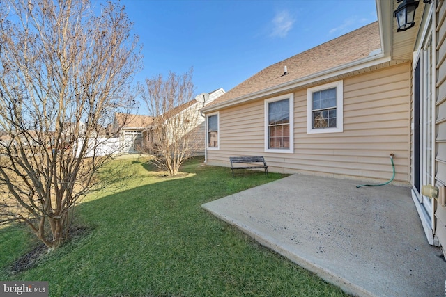 back of house with a patio area and a lawn