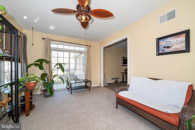 living area with carpet and ceiling fan