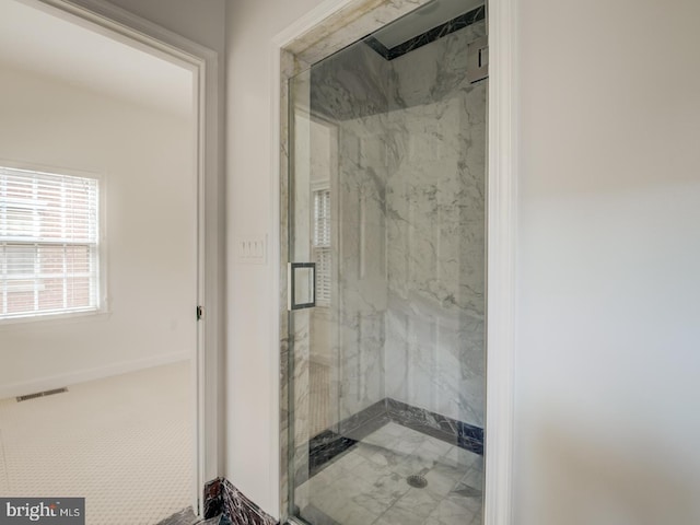 bathroom featuring a shower with door