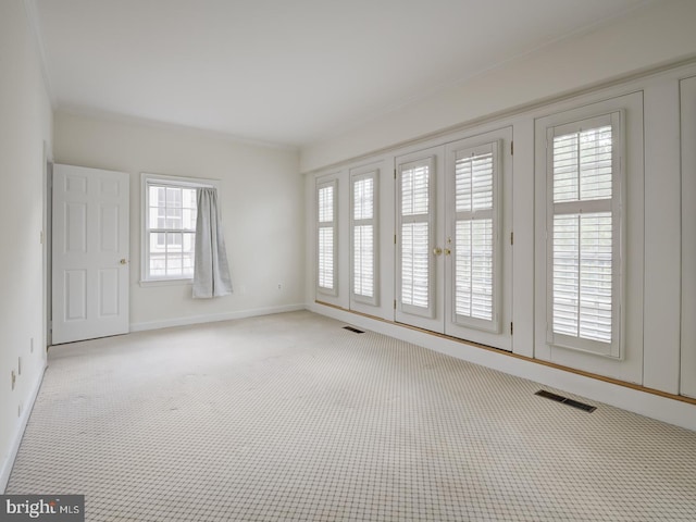 carpeted spare room featuring crown molding