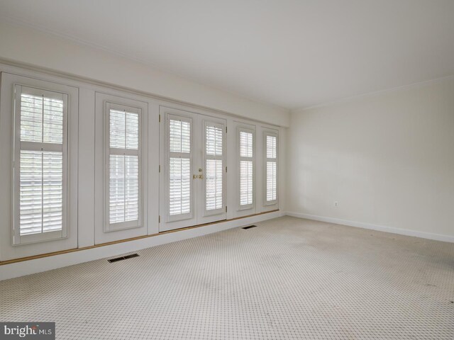 unfurnished room with crown molding and carpet floors