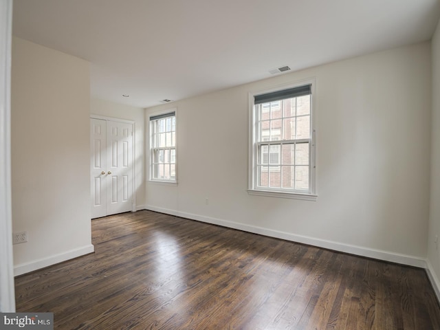 spare room featuring dark wood-type flooring