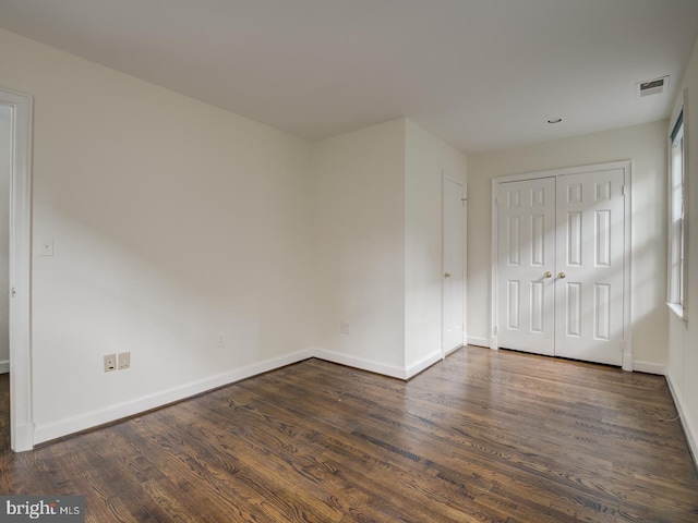 spare room with dark wood-type flooring