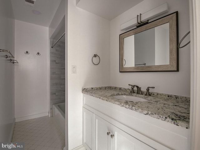 bathroom with tiled shower / bath and vanity