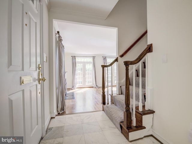 foyer with crown molding and french doors