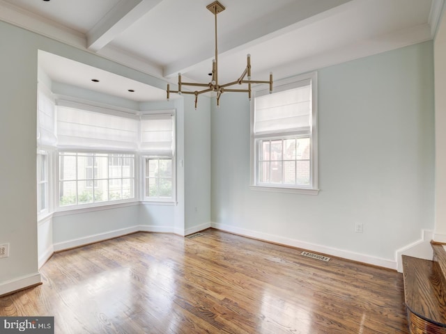 empty room with an inviting chandelier, hardwood / wood-style floors, and beamed ceiling