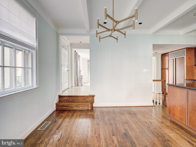 spare room with a chandelier, hardwood / wood-style floors, and beam ceiling