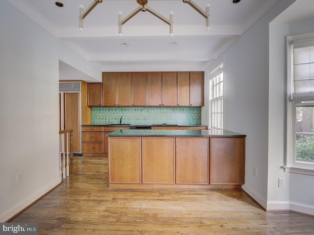 kitchen with sink, light hardwood / wood-style flooring, backsplash, beam ceiling, and plenty of natural light