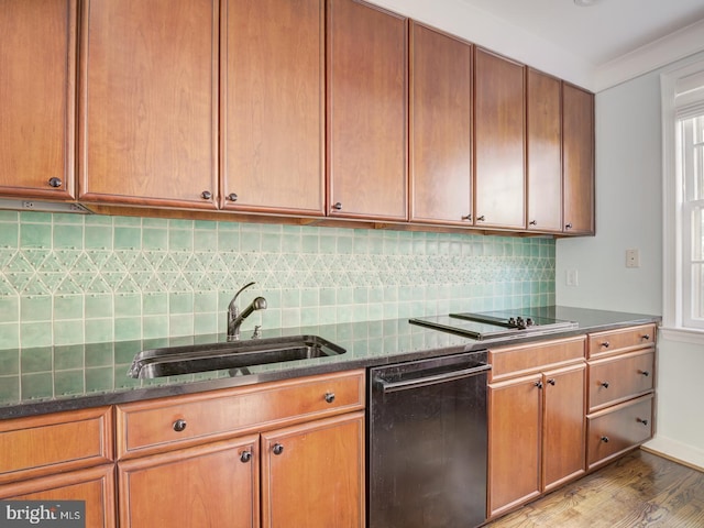 kitchen featuring sink, crown molding, tasteful backsplash, black appliances, and dark stone counters