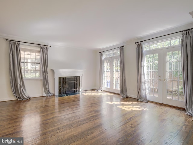 unfurnished living room with crown molding, hardwood / wood-style flooring, and french doors