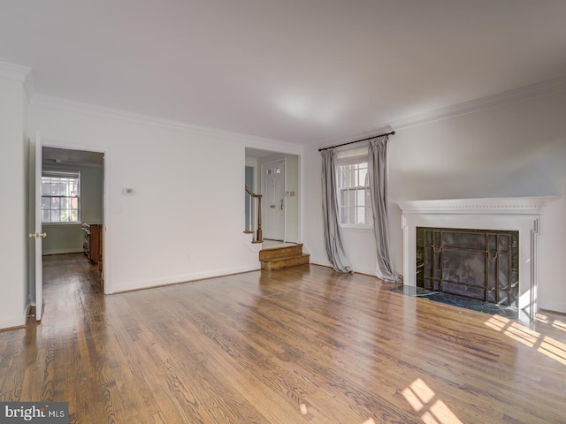 unfurnished living room featuring crown molding, hardwood / wood-style flooring, and a wealth of natural light