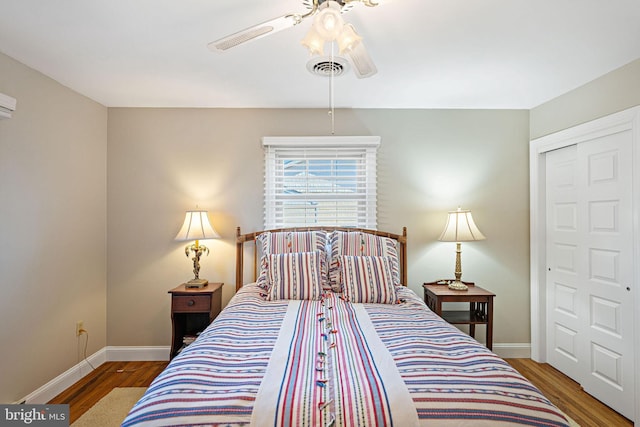 bedroom featuring wood-type flooring, ceiling fan, and a closet