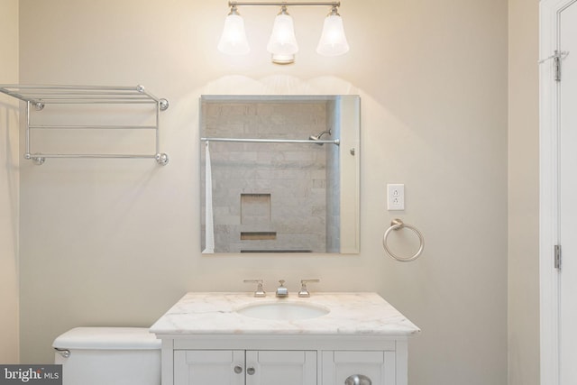 bathroom with walk in shower, vanity, and toilet