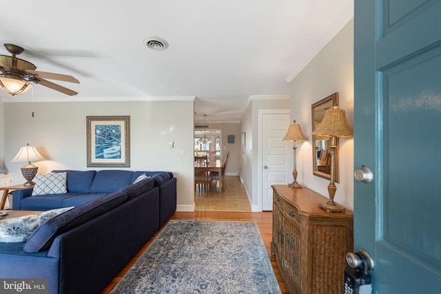 living room featuring crown molding, ceiling fan, and light wood-type flooring